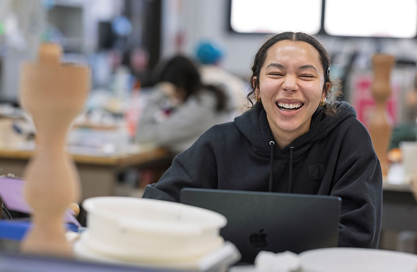 Photo of a student with a laptop laughing. Read about What to Give Photo of a student with a laptop laughing. Read about What to Give
