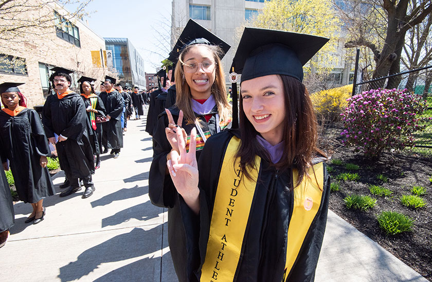 Photo of students at graduation standing in a line and smiling. Read about Gifts from Retirement Plans